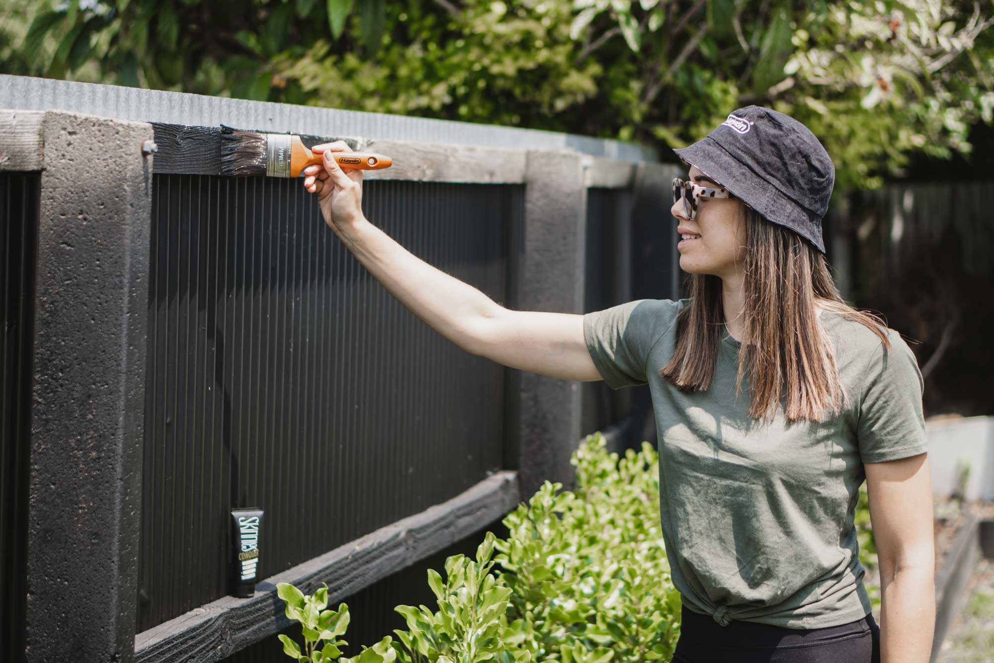 Georgia from Moochstyle painting her fence in Christchurch using Haydn's Leeda Brush